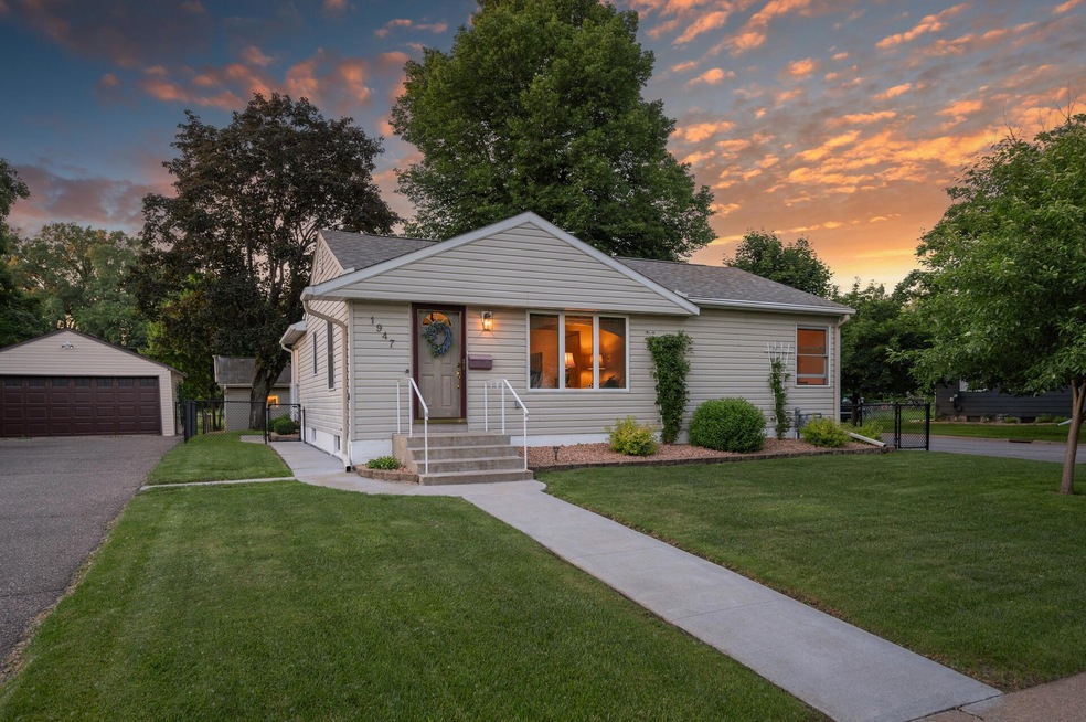 A cream-sided rambler at 1947 Field Avenue in Saint Paul photographed at sunset, with a landscaped front walk